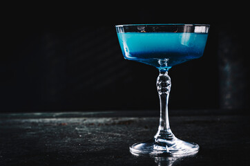 Blue lagoon cocktail with blue curacao liqueur, vodka, lime juice and soda on table