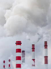 Smoke and steam rise from industrial chimneys of a heating power plant.