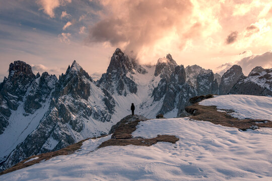 Anonymous traveler admiring mountain peaks in winter