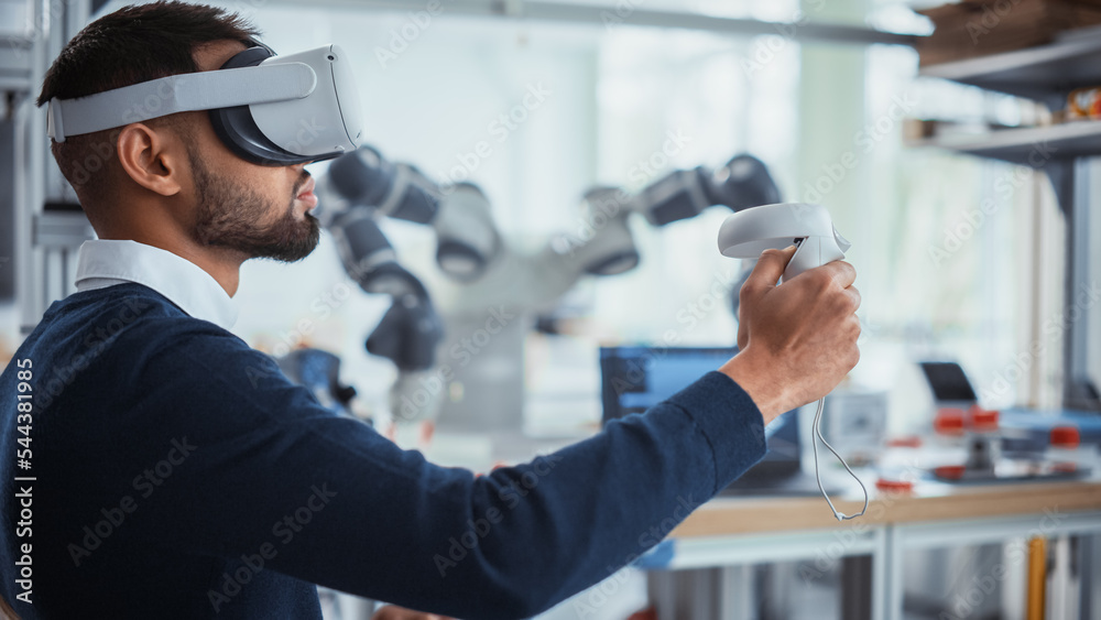 Poster Computer Science Worker in Virtual Reality Headset Holding Controllers and Moving Bionic Claw. Man Developing Program for Motion of Robotic Arm. Innovative Automation Technologies Concept.