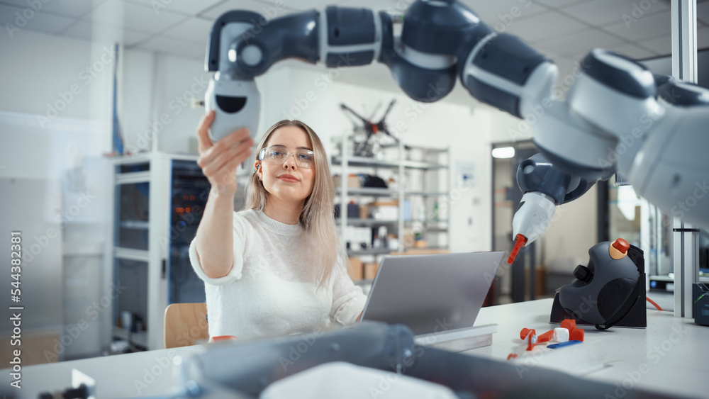 Aufkleber female automation engineer types on laptop and moves bionic claw at the factory. modern and futurist