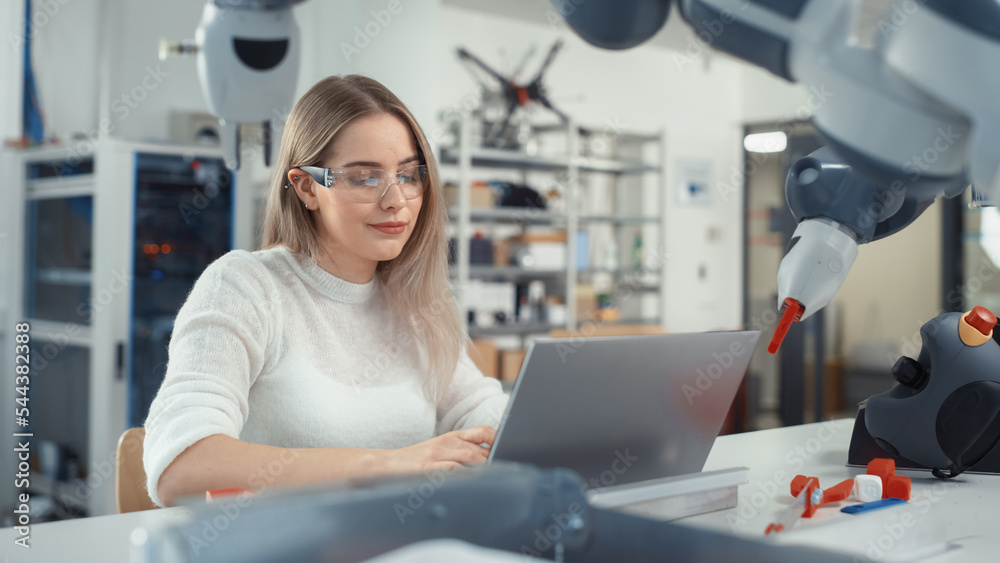 Poster Female Automation Engineer Writes Code on Laptop and Moves Bionic Claw At the Factory. Modern and Futuristic Robotic Equipment Starts the New Era in Computer Science Industry Concept.