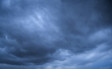Storm clouds floating in a rainy day with natural light. Cloudscape scenery, overcast weather above blue sky. White and grey clouds scenic nature environment background