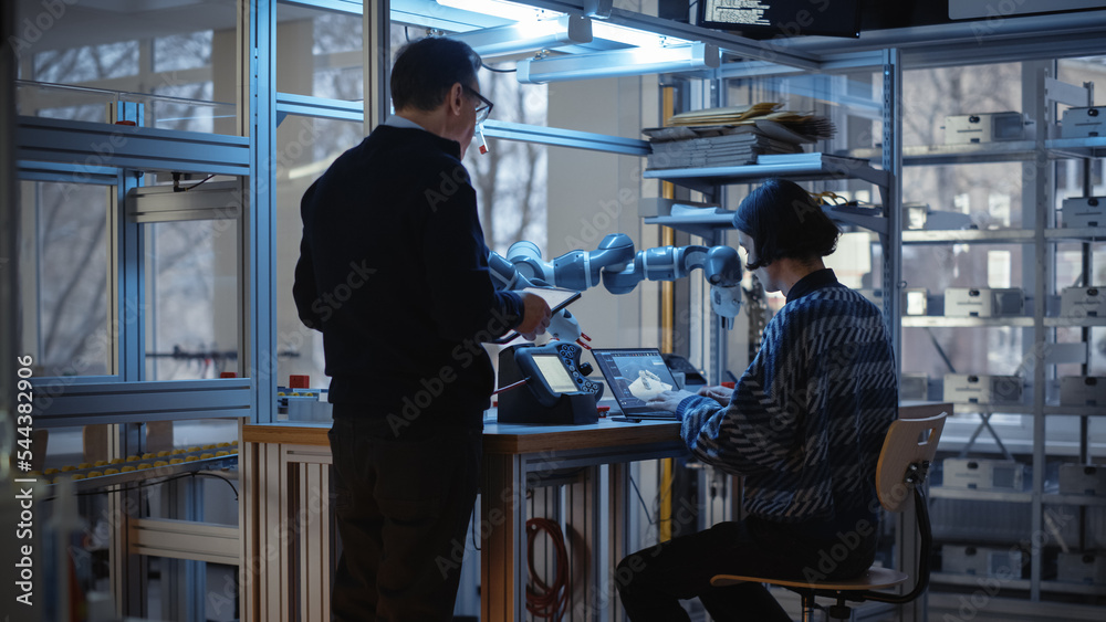 Aufkleber Skilful Male Engineer with Tablet Gives Advice to Young Computer Developer While He Writes Code for Robotic Limb Application. People Designing Automated Robotic Systems Concept.