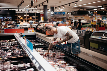Man choosing meat in grocery store