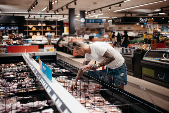 Man choosing meat in grocery store