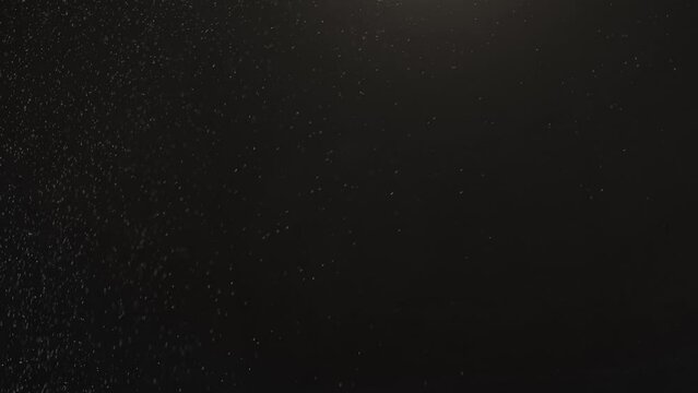 Dust falling on dark background