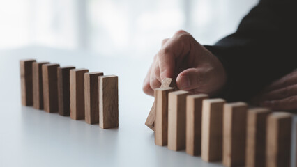 A close-up shot of a businessman holding the wooden blocks in a row, the wood blocks compare to the...