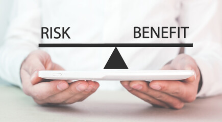 Man showing words Risk and Benefit in balance.