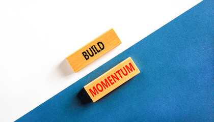 Build momentum symbol. Concept words Build momentum on wooden blocks. Beautiful white and blue background. Business and build momentum concept. Copy space.