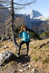 Naklejka premium Smiling Curly Hair Toothy Smile Mid Adult Woman Hiker Looking at Camera in Alpine Autumn Environment 