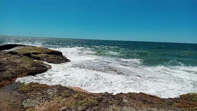 Waves crashing on the rocks of Rio das Ostras beach, Costa Azul of Rio de Janeiro, Brazil