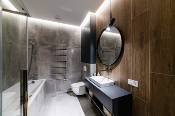 Bathroom in loft style with round mirror