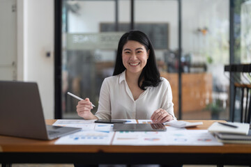 Obraz na płótnie Canvas Portrait Of Attractive Asian Businesswoman Working On Laptop for marketing plan.