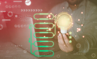 Man hand holding light bulb with empty process workflow and three star on virtual screen. Concept...