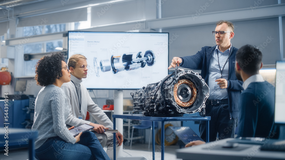 Poster male engineer talks about performance of turbine engine to a group of young specialists. people work