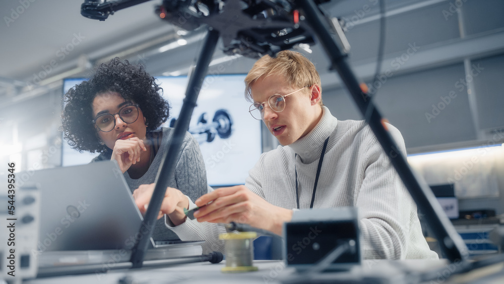 Aufkleber black professional female developer coding on laptop while her young male colleague holding semicond