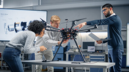Young Specialists Connecting Drone to a Laptop. Engineers Try to Make Jobs Safer, Easier and More Efficient by Automated Contactless Delivery Machines. Professionals Work in Aviation Industry.