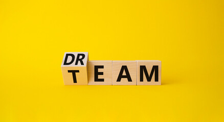 Dream Team symbol. Wooden cube with words Dream Team. Beautiful yellow background. Business and...