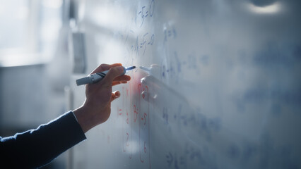 Fototapeta Macro Shot of a Blue Marker Pen Being Held with a Hand. Teacher Writing Equations on a Whiteboard with Mathematical Formulas. Higher Education in University of Technology Concept. obraz