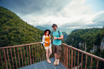 Woman and man. Happy couple, travelers in Okatse Canyon, Georgia, standing on hanging metal...