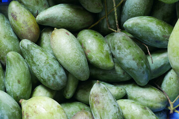 Fresh green mango on black background top down.