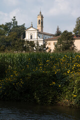 Panoramic view
Portion of view of river Lambro, flowers, and part of external facade of church surrounded by greenery.