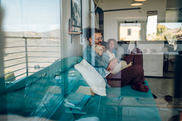 Couple petting their adopted dog while sitting on the couch at home
