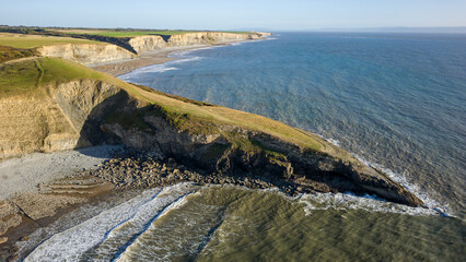 Aerial view of limestone cliffs and a rock covered sandy beach