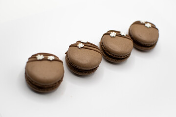 Braune Macarons mit Schneeflocken dekoriert, im Set von oben