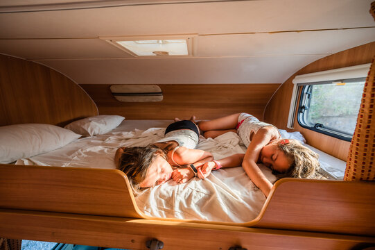Kids are sleeping in alcove motorhome on road trip vacations.