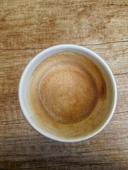 a glass of coffee stands on a wooden table, cafe