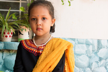 Indian girl in black traditional clothes smiling and lookin at camera, welcome expression of...