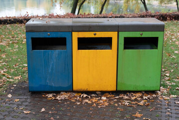 Obraz premium Blurred image of different colored trash cans for garbage sorting.