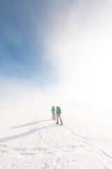 Fototapeta na wymiar two girls in snowshoes walk in the snow. hiking in the mountains in winter.