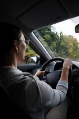 young woman driving a car on autumn road