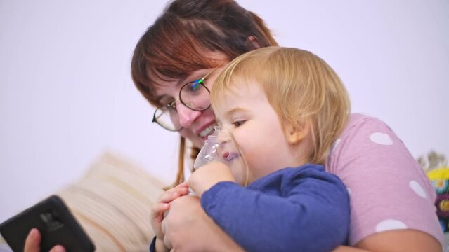 Mother Helping Adorable Caucasian Baby Girl Inhalating Medicine Steroids to Recover Respiratory Disease