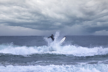 A boy surfs along the mediterranean coast in gaeta. professional surfer riding waves in Bali, Indonesia. men catching waves in ocean, isolated. Surfing action water board sport. people water sport