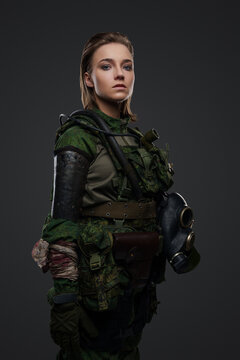 Portrait of isolated on grey background soldier woman dressed in camouflage costume.