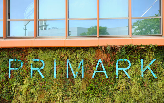 Primark logo outside a commercial store on a vertical garden background. Primark in Seville. Primark in Spain