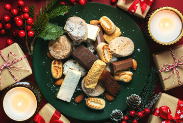 Top view of Nougat christmas sweet,mantecados and polvorones with christmas ornaments on a plate....
