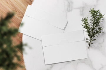 Clean minimal letter mockup on top mable table with conifer and plant