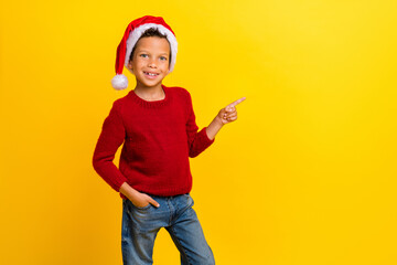 Fototapeta na wymiar Photo portrait of cute little boy point copyspace christmas north pole wear trendy red knitwear look isolated on yellow color background