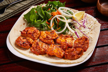 Spicy Sheesh Tawook or shish tikka boti kebab with salad, lemon and bread served in dish isolated...