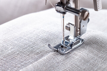 Modern sewing machine presser foot with linen fabric and thread, closeup, copy space. Sewing...