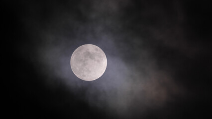Obraz na płótnie Canvas Full moon in clouds in California sky.