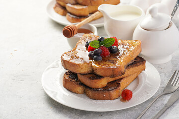 Several pieces of french toast - white wheat bread soaked in egg, milk and sugar, fried on a pan -...