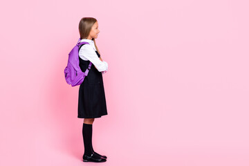 Full body size photo of preteen cute small schoolkid girl wear uniform buy new backpack sale shopping look empty space advert isolated on pink color background