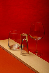 A set of glassware on a wooden board on a red background