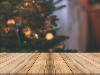 Empty wooden tabletop and blur room with a Christmas tree background, suitable for montage product